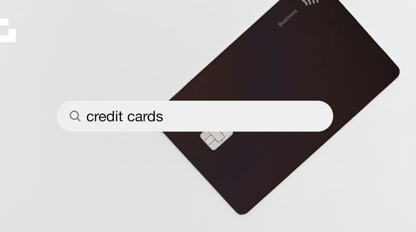 An illustration of a dark payment card behind a search field reading credit cards.
