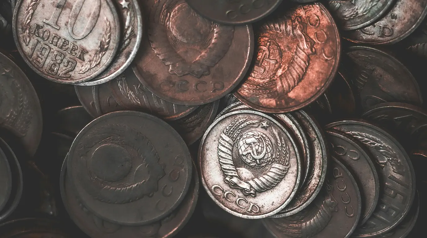 A tight pile of worn copper and silver coins stamped with wheat-sheaf crests and Cyrillic lettering.