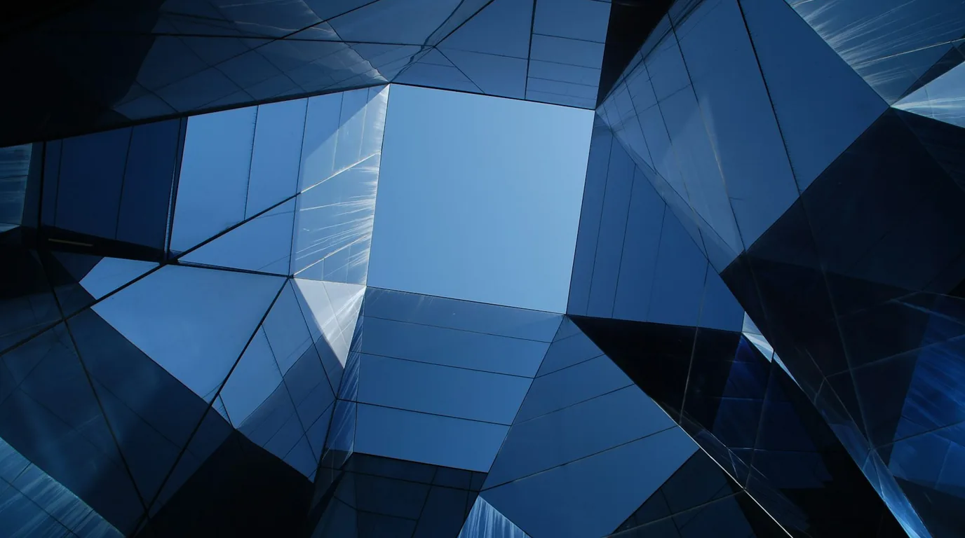 Angular blue glass panels of a tower, reflections folding into one another.