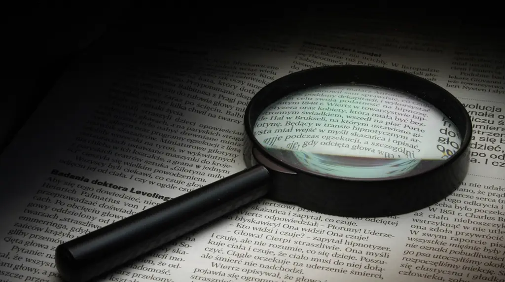 A magnifying glass lying on a page of newsprint
